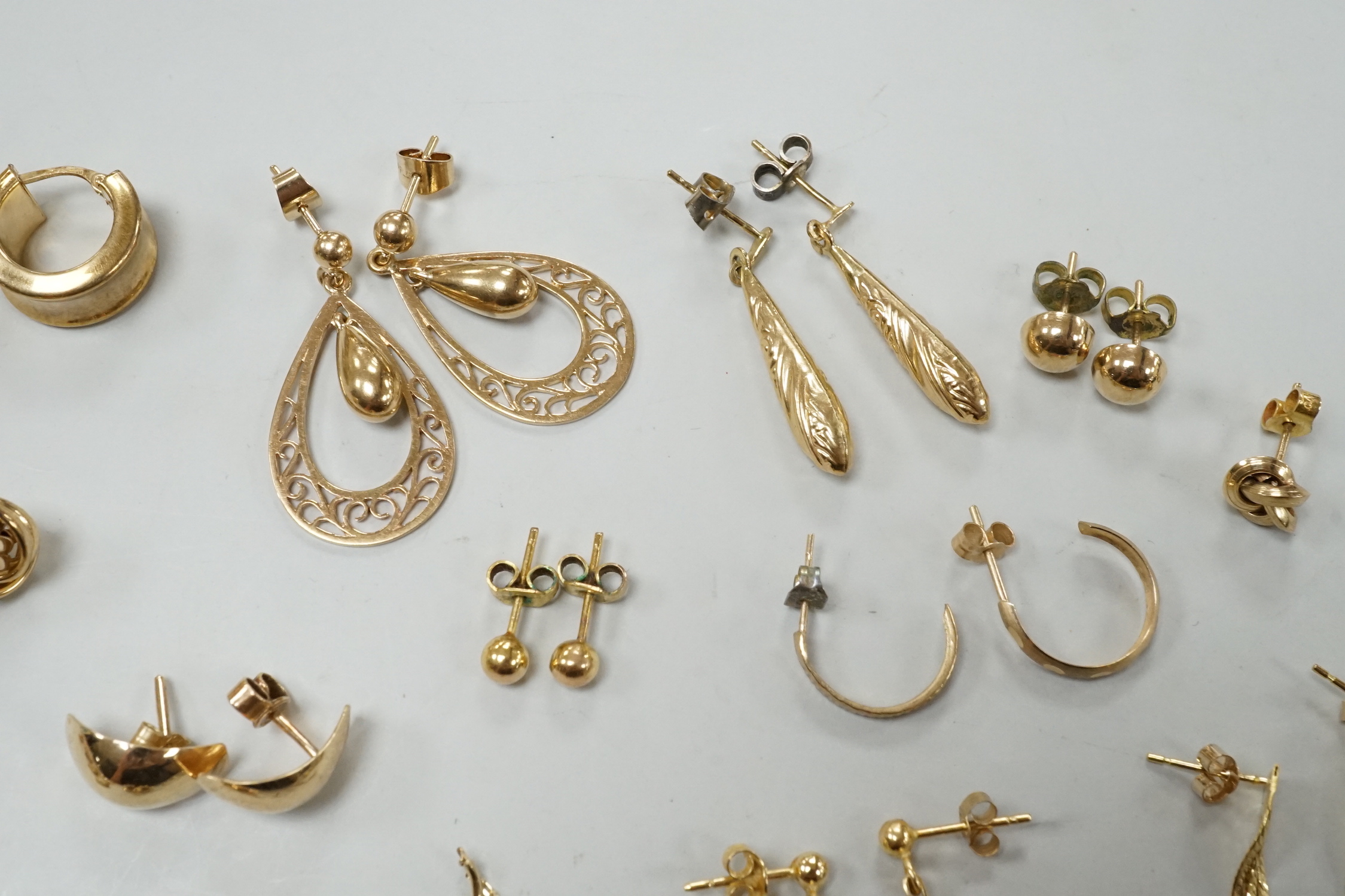 Seven assorted modern pairs of 9ct earrings including tassel drop and pear shaped, 12.7 grams and ten other yellow metal pairs, three odd ear studs and a small heart pendant?